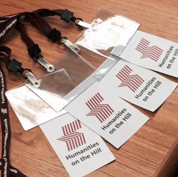 badge on lanyards laid out on a table. They  say "Humanities on the Hill."